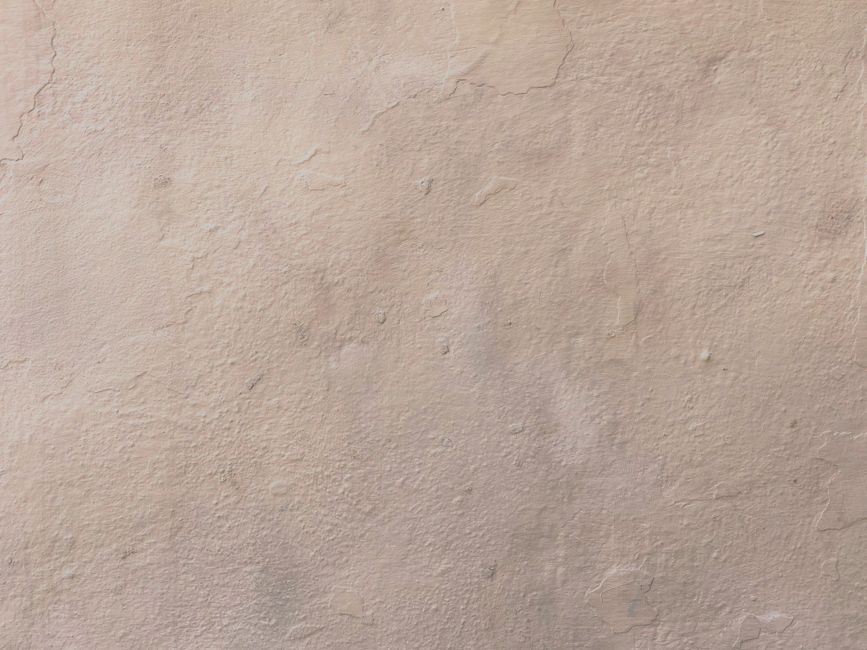 Close-up of a beige textured plaster wall surface, ideal for backgrounds.